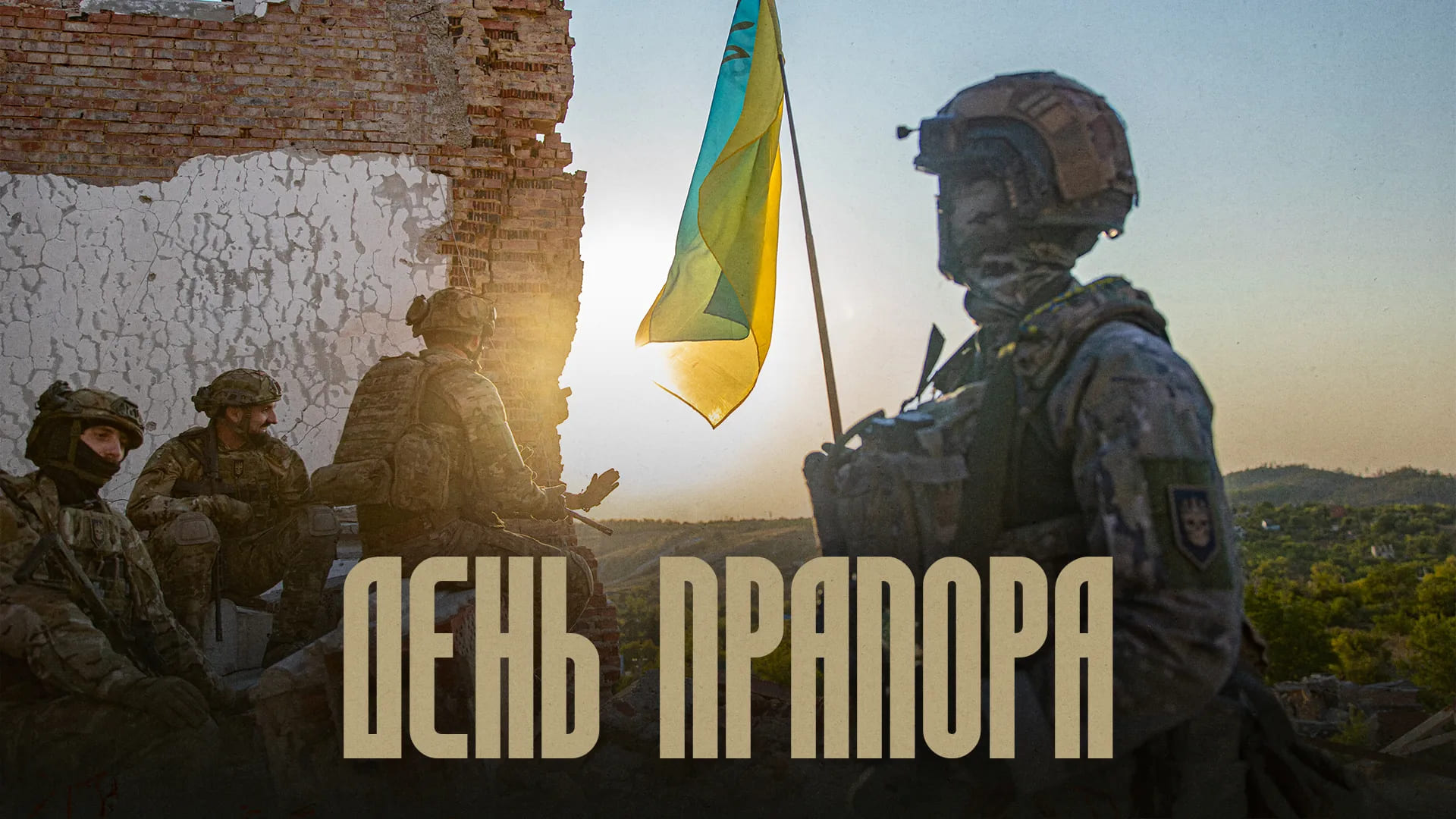 Бійці Любарт на фоні руїн будинку, напис "День прапора"