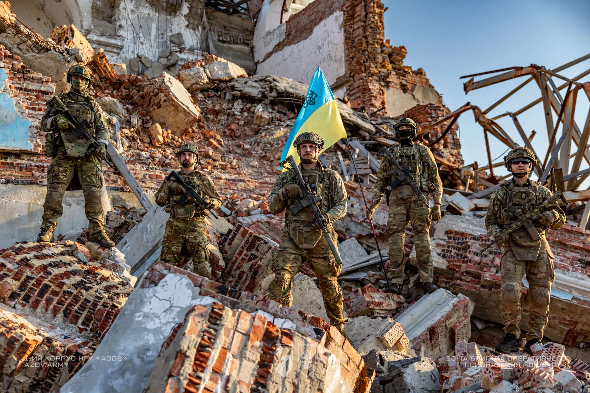 Бійці бригади Любарт на фоні руїн будинку та українського прапору