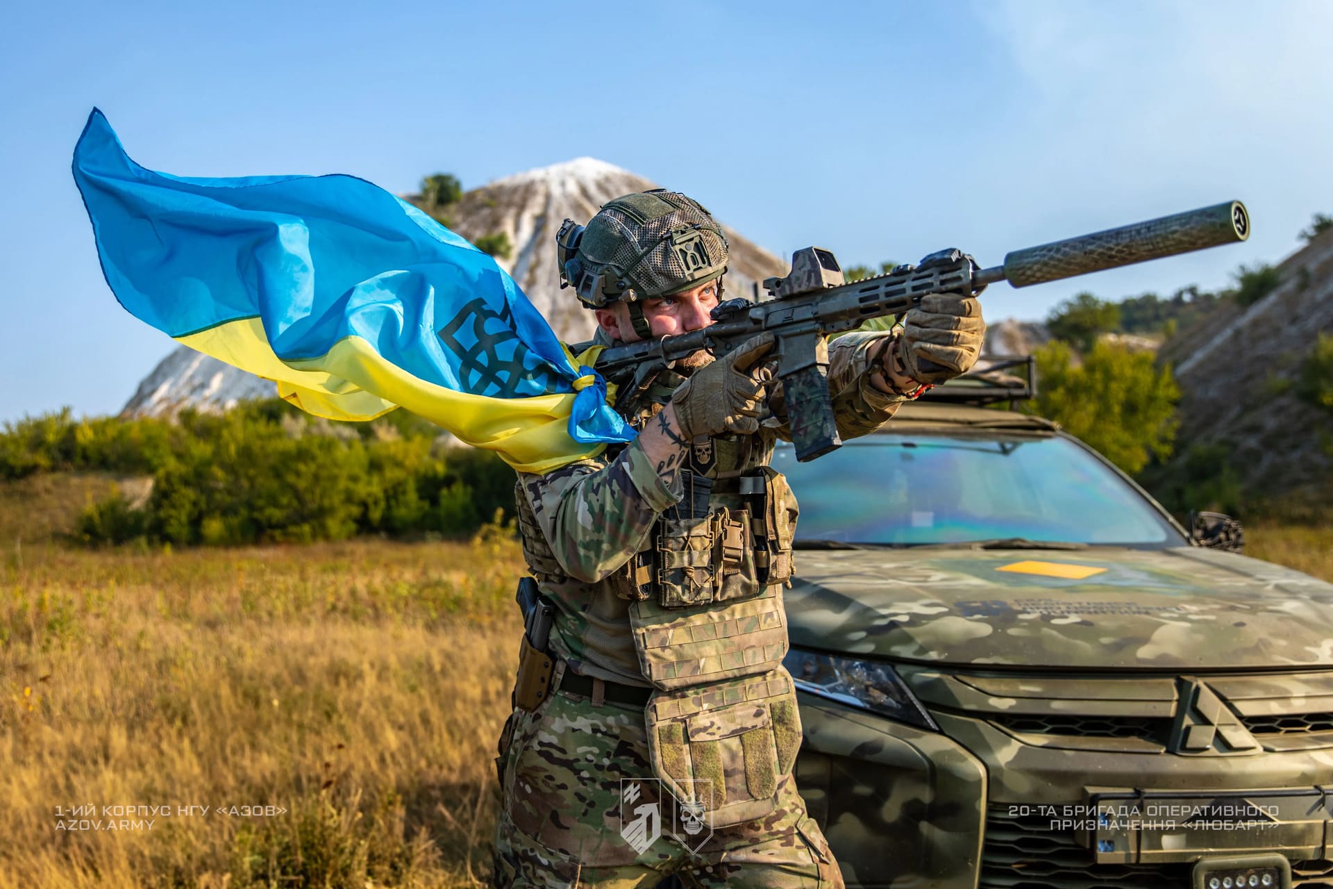 Прапор прив'язаний до бійця бригади Любарт, який цілиться з гвинтівки