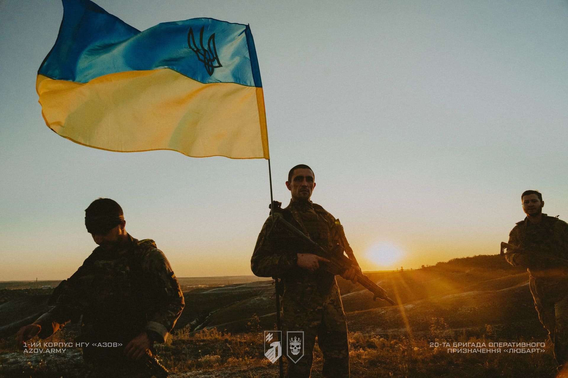 Бійці Любарт на фоні заходу сонця та українського прапору