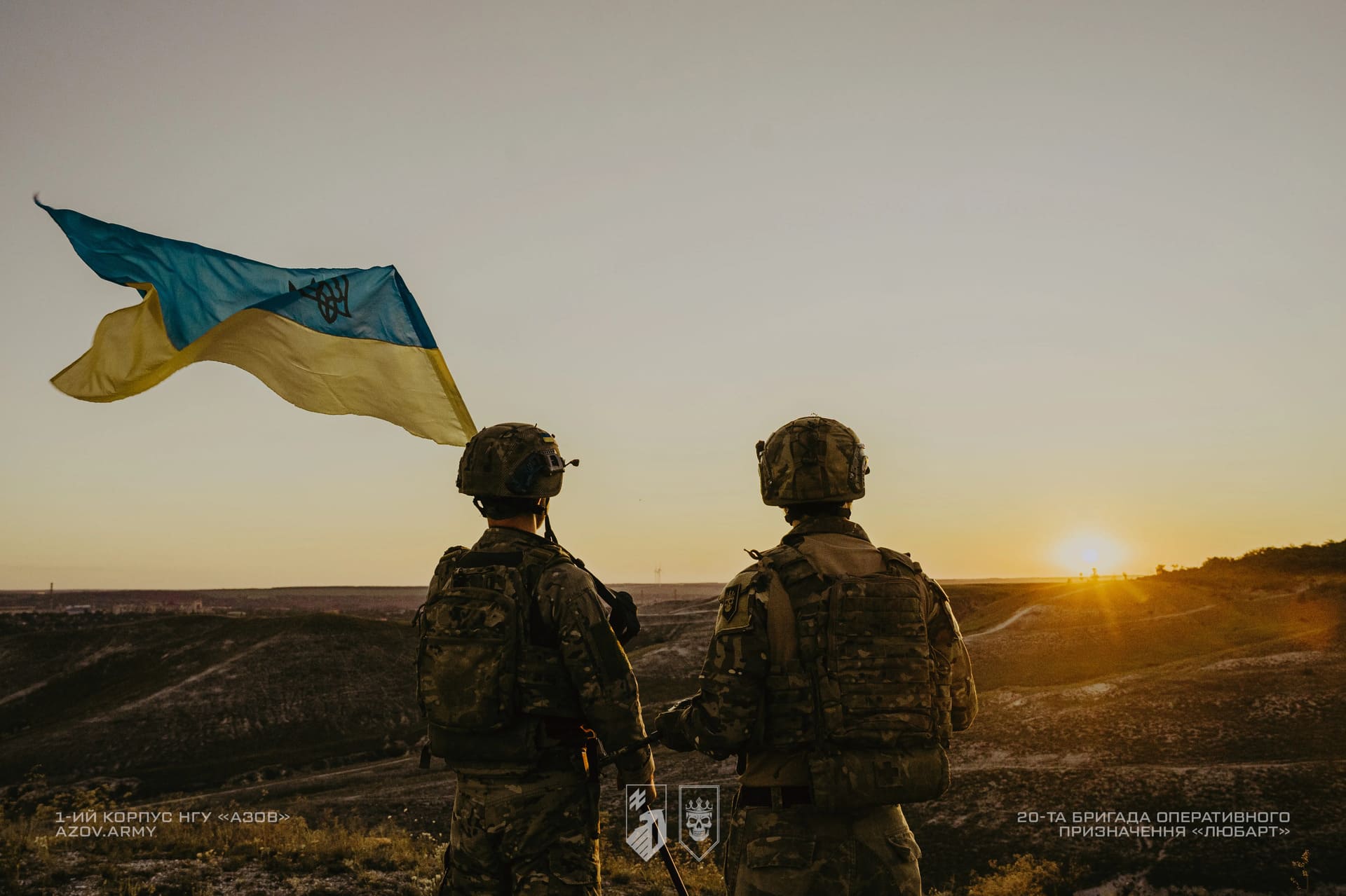 Бійці Любарт на фоні заходу сонця тримають український прапор