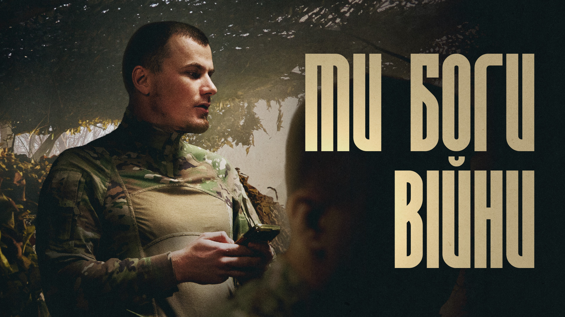 Військовослужбовець з телефоном в руках, напис "Ми - боги війни"