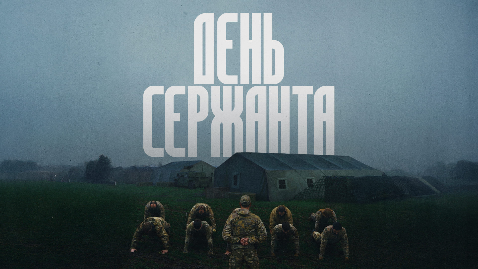 Сержант стоїть навпроти бійців в упорі лежа, на фоні наметового містечка