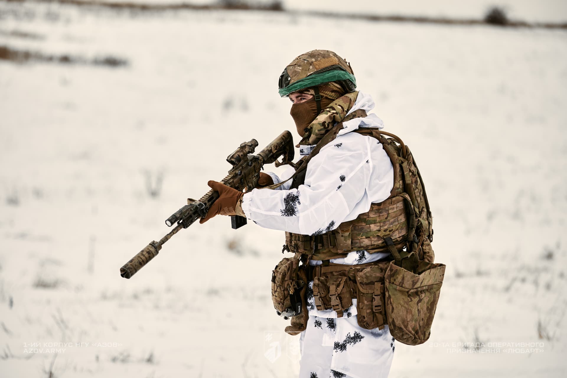 Військовослужбовець в зимовому екіпіруванні тримає зброю
