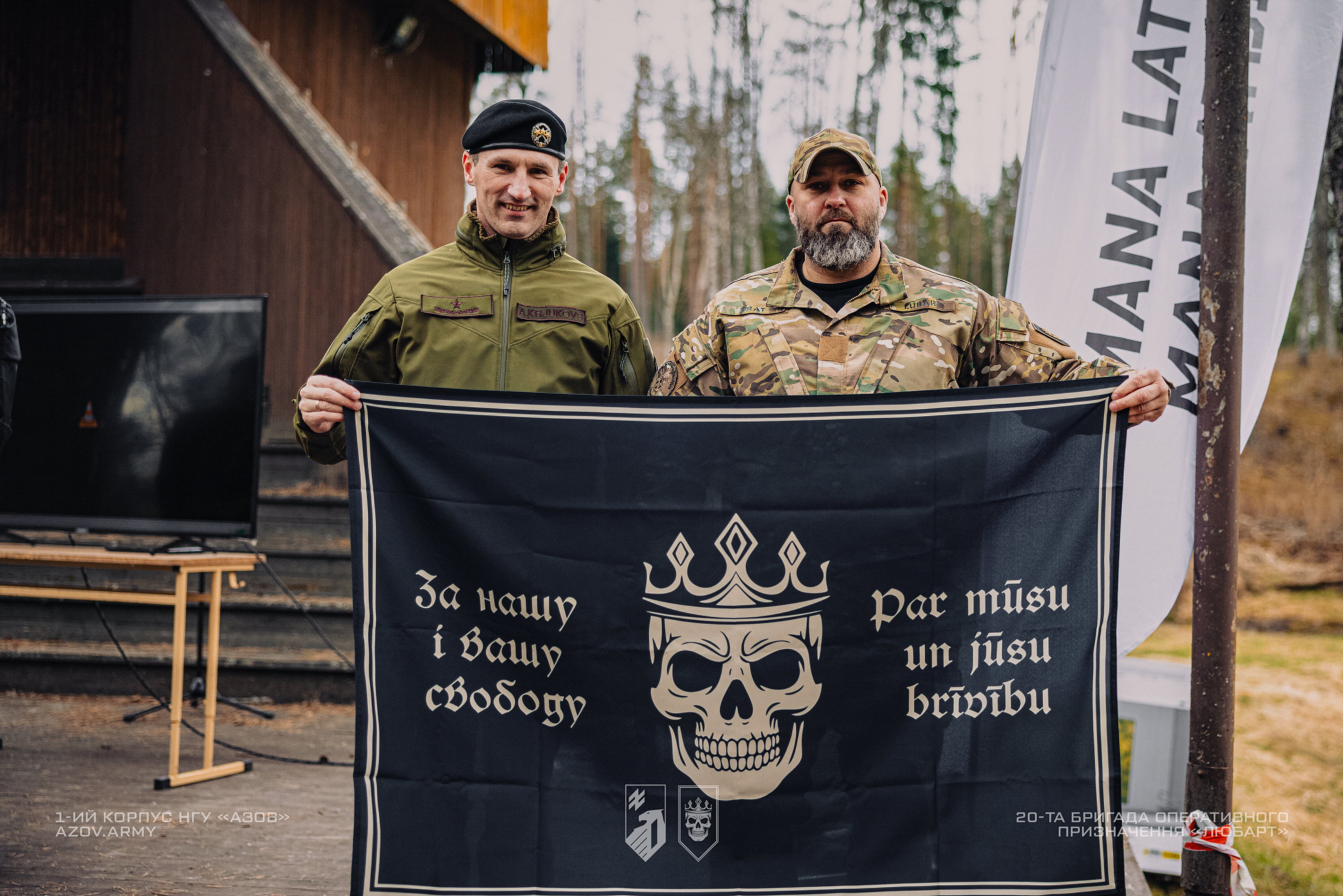 військові тримають прапор із символом Любарта та написом про свободу