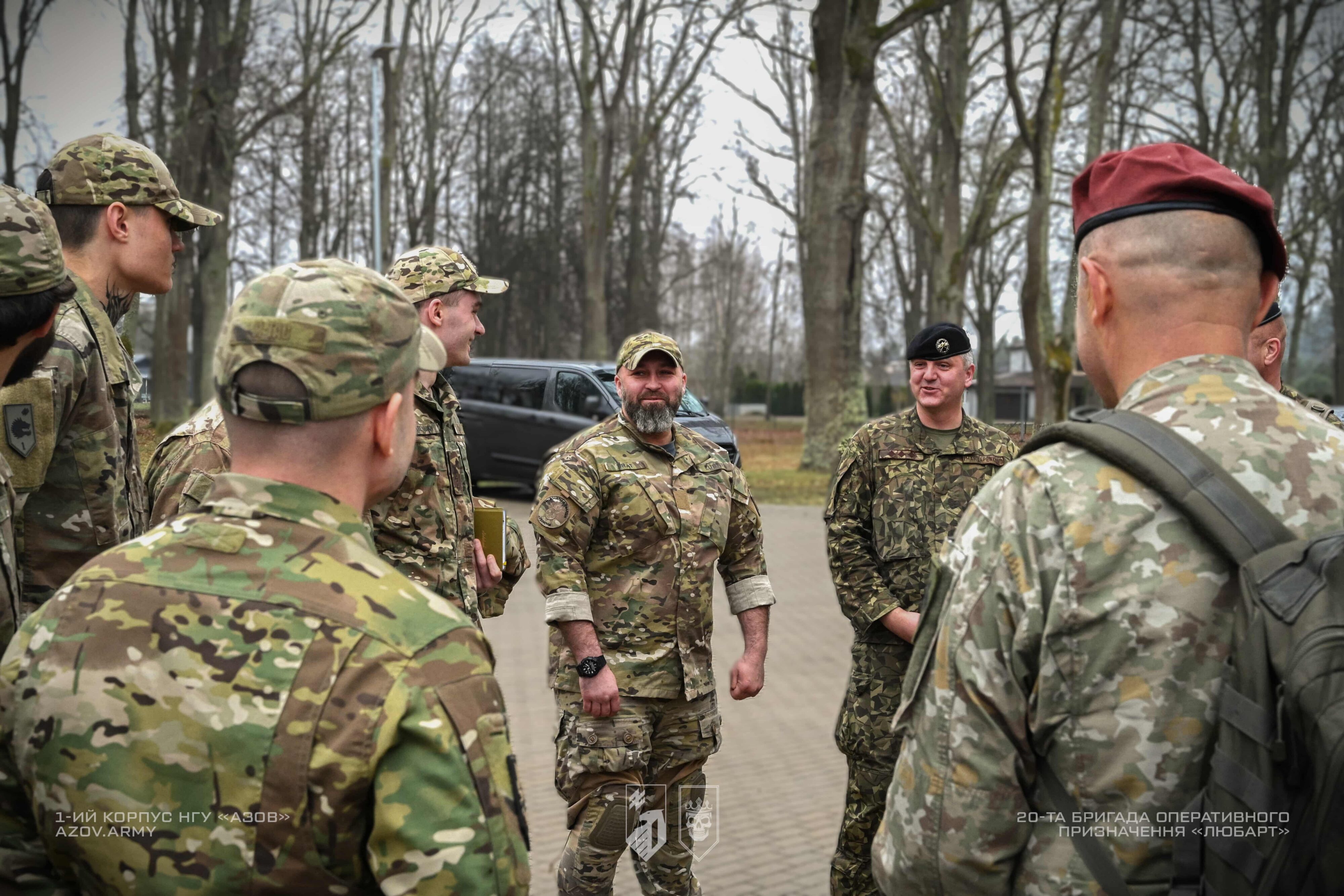 група військових спілкується під час зустрічі на відкритій території