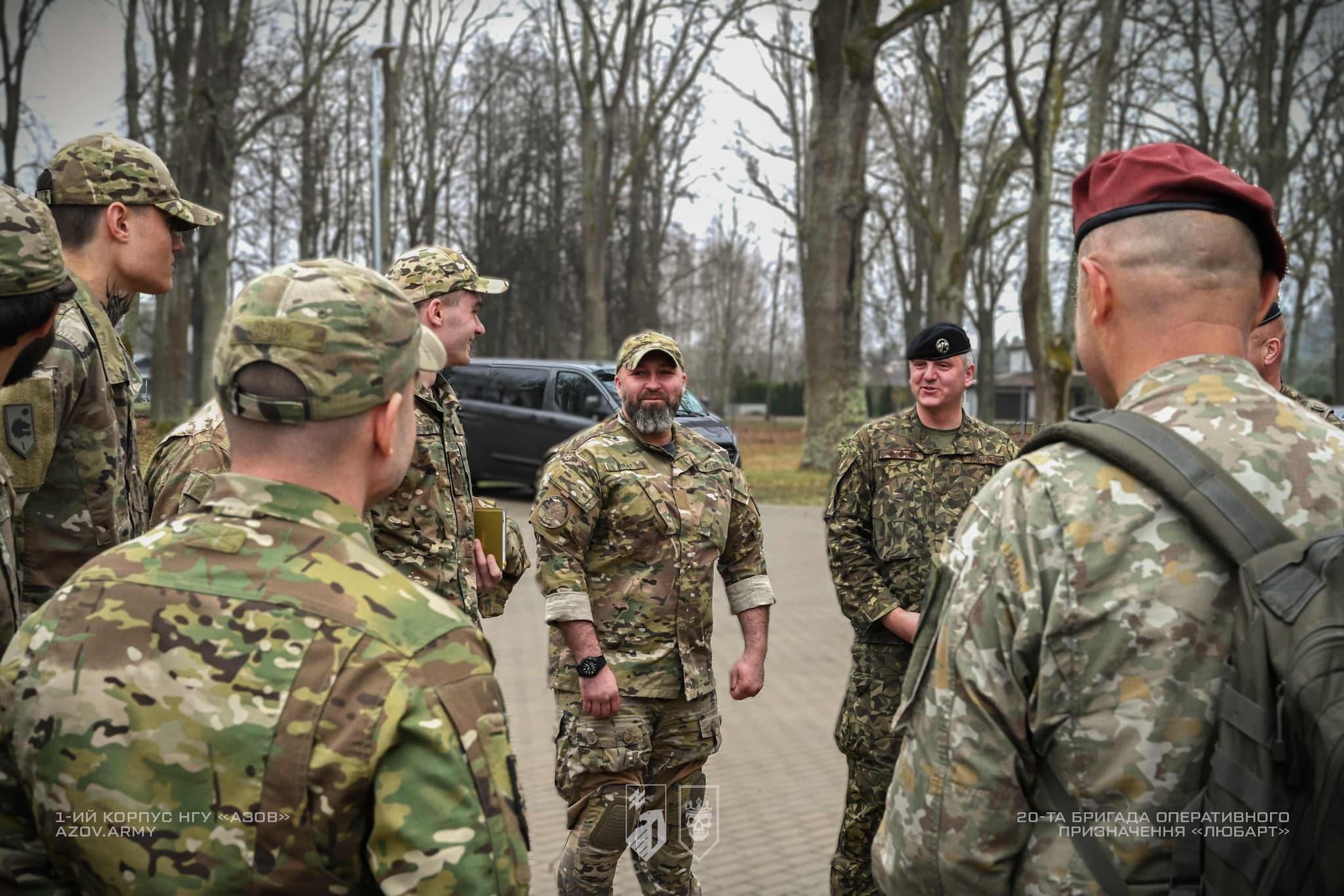 група військових спілкується під час зустрічі на відкритій території