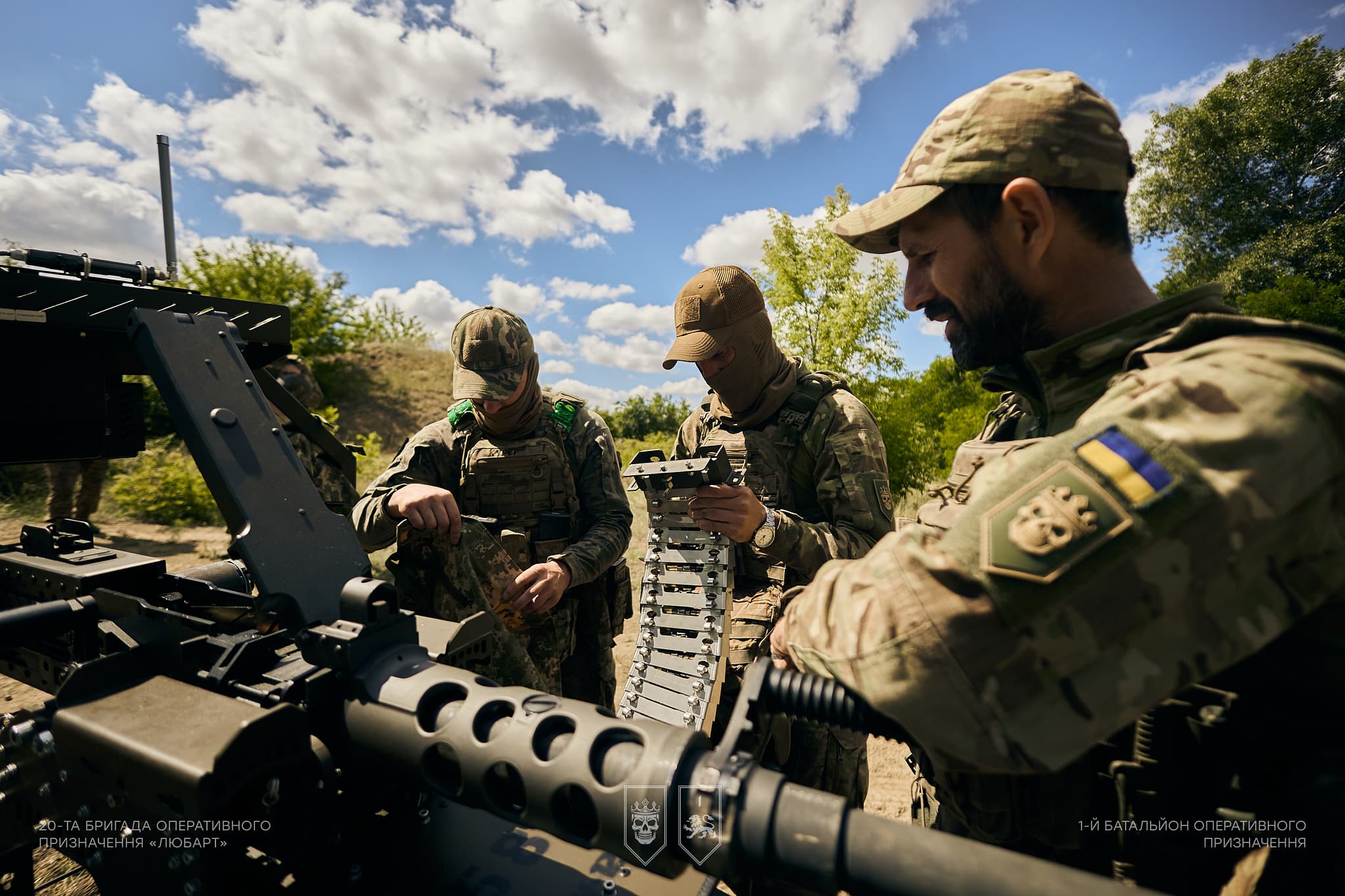 Військовослужбовці заряджають стрічку з набоями до кулемета Browning на НРК.